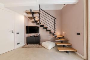 a living room with a staircase and a tv at ES Suites in Naples