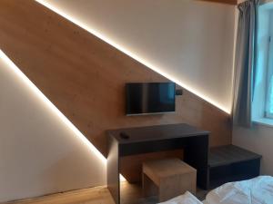 uma sala de estar com uma televisão e uma mesa num quarto em Appartamento Vale e Schena Cortina D'Ampezzo em San Vito di Cadore