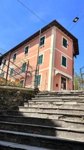 un edificio rosa con escaleras delante en Golfo Paradiso Campane di Uscio piccola bomboniera pochi chilometri Camogli Portofino Santamargherita, en Uscio