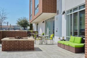 eine Terrasse mit einem grünen Sofa, einem Tisch und Stühlen in der Unterkunft SpringHill Suites by Marriott Dallas Lewisville in Lewisville