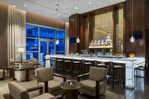 a restaurant with a bar with chairs and tables at SpringHill Suites by Marriott Nashville Downtown/Convention Center in Nashville