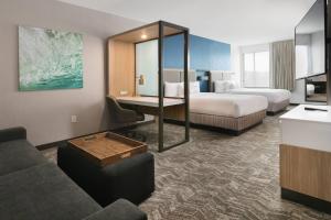 フォートワースにあるSpringHill Suites Dallas DFW Airport South/CentrePortのベッド2台とソファが備わるホテルルームです。