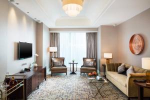 a living room with a couch and a tv at The St. Regis Chengdu in Chengdu