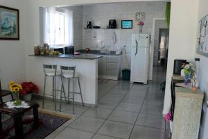 uma cozinha com um frigorífico branco e piso em azulejo em Pousada Decarli Executiva Aeroporto Florianópolis em Florianópolis
