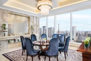 a dining room with a table and chairs and a large window at The St. Regis Chengdu in Chengdu