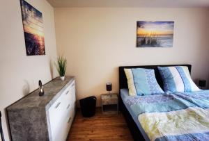 a bedroom with a bed and a dresser at Ferienwohnung im Starenweg in Blankenburg