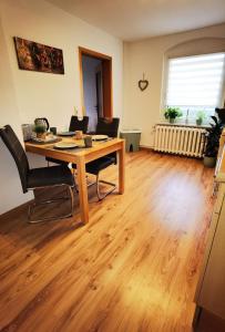 uma sala de estar com uma mesa de madeira e cadeiras em Ferienwohnung im Starenweg em Blankenburg