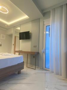 Schlafzimmer mit einem Bett und einer Glasschiebetür in der Unterkunft Valentina Hotel in Paralia Katerinis
