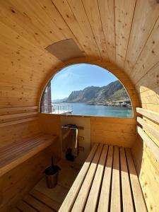 een sauna met een raam in een houten hut bij Lofoten Waterfront luxury lodge in Ballstad