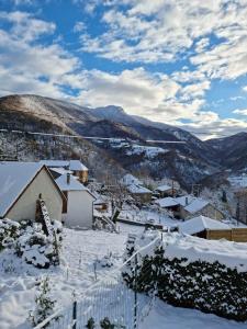 un pueblo cubierto de nieve con montañas en el fondo en Legiteducerf, en Sengouagnet