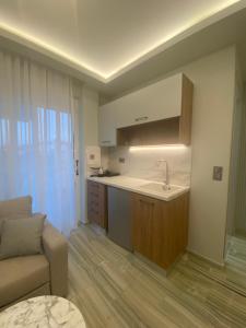 una cocina con fregadero y un sofá en una habitación en Valentina Hotel, en Paralia Katerinis