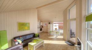 Timmenhus - Ferienhäuser am Feldrand في تيميندورفير ستراند: غرفة معيشة بها أريكة وطاولة +9 صور