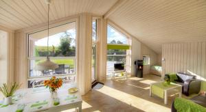 a living room with a large window and a couch at Timmenhus - Ferienhäuser am Feldrand in Timmendorfer Strand