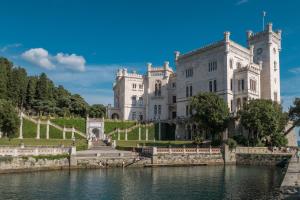 un castello con un lago di fronte di MyWay Trieste Rooms a Trieste