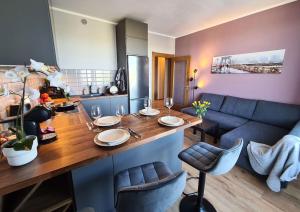 a kitchen with a table with chairs and a couch at Stylish apartment with parking & spacious balcony in Riga
