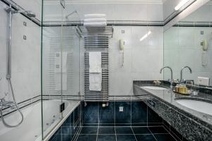 La salle de bains est pourvue de 2 lavabos et de 2 miroirs. dans l'établissement Grand Hotel Suisse Majestic, Autograph Collection, à Montreux