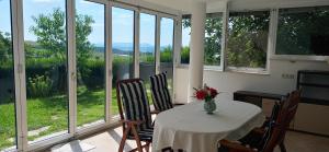 a dining room with a table and chairs and windows at Apartma pri Boru in Ptuj