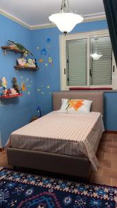 a bedroom with a bed with a blue wall at Villa Maria in Reggio di Calabria