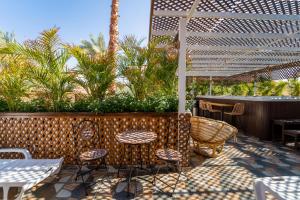 a patio with tables and chairs and a pergola at South Star Suites in Eilat