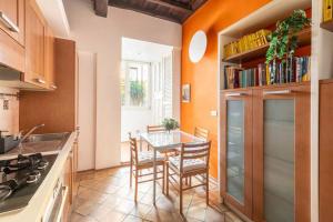 uma cozinha com mesa e cadeiras num quarto em Maison Leonardo al Colosseo em Roma