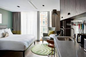 a bedroom with a bed and a kitchen with a sink at Residence Inn by Marriott London Kensington in London