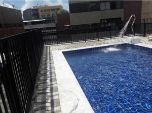een zwembad met een glijbaan in een gebouw bij Excelente quarto/sala in Maceió