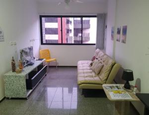 een woonkamer met een bank en een tafel bij Excelente quarto/sala in Maceió
