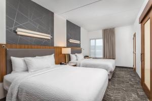 2 Betten in einem Hotelzimmer mit weißer Bettwäsche in der Unterkunft SpringHill Suites by Marriott Downtown Chattanooga/Cameron Harbor in Chattanooga