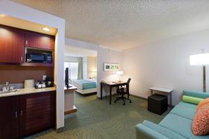 Habitación de hotel con cama y sala de estar. en SpringHill Suites Denver North / Westminster, en Westminster