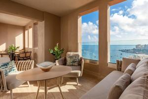 a living room with a view of the ocean at Malta Marriott Resort & Spa in St. Julianʼs