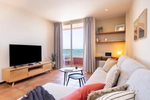 ein Wohnzimmer mit einem Sofa und einem Flachbild-TV in der Unterkunft Spectacular Beachfront Loft-Style CASA CORINA II in El Médano