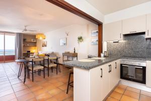 eine Küche und ein Wohnzimmer mit einem Tisch und Stühlen in der Unterkunft Spectacular Beachfront Loft-Style CASA CORINA II in El Médano