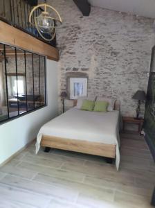 um quarto com uma cama e uma parede de pedra em Saint Laurent em Portes-en-Valdaine