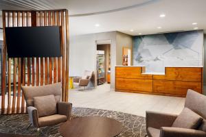 a lobby with chairs and a flat screen tv at SpringHill Suites Boulder Longmont in Longmont