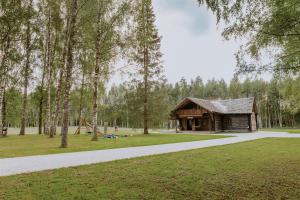 a log cabin in a park with a path at Holiday home Migliņas in Kaugurmuiza