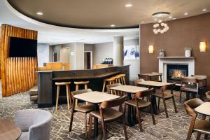 a restaurant with tables and chairs and a fireplace at SpringHill Suites Boulder Longmont in Longmont