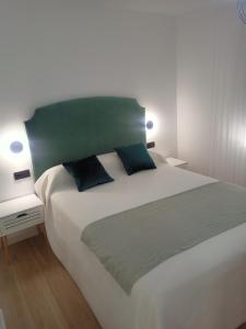 sypialnia z dużym białym łóżkiem z 2 poduszkami w obiekcie Apartamento Granada-Ronda w Grenadzie