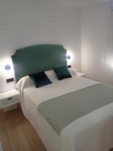 sypialnia z dużym białym łóżkiem z 2 poduszkami w obiekcie Apartamento Granada-Hipercor w Grenadzie