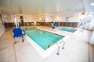 a large swimming pool with a blue chair in a building at SpringHill Suites Lumberton in Lumberton