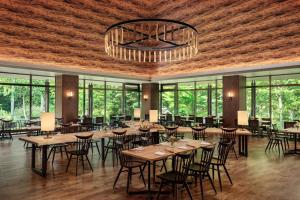 a dining room with tables and chairs and windows at Courtyard by Marriott Hakuba in Hakuba