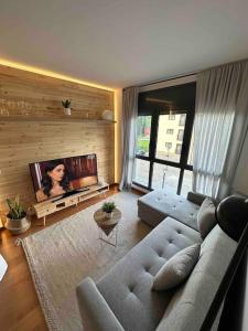 a living room with a couch and a flat screen tv at Precioso Piso en La Molina in La Molina