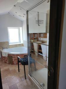 a bathroom with a tub and a chair in a room at Saint Laurent in Portes-en-Valdaine