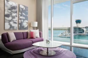 a living room with a purple couch and a table at W Abu Dhabi - Yas Island in Abu Dhabi