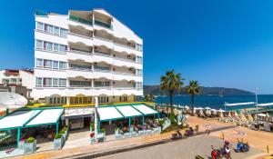 un gran edificio blanco junto al océano en Honeymoon Beach Marmaris, en Marmaris