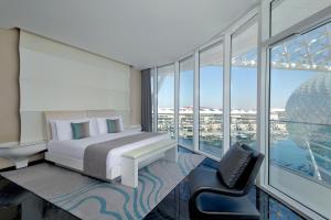 a hotel room with a bed and a chair at W Abu Dhabi - Yas Island in Abu Dhabi