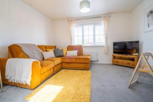 a living room with a couch and a television at Butterfly Gardens 2 bed apartment sleep upto 4 in Woodville