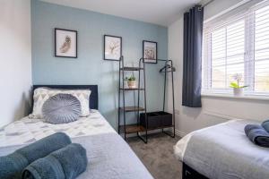 1 dormitorio con 2 camas y estante en Butterfly Gardens 2 bed apartment sleep upto 4, en Woodville
