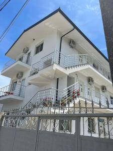 a white building with balconies and flowers on it at Kleida Beach Vacation Rentals in Spille