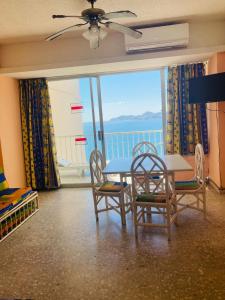ein Esszimmer mit einem Tisch und Stühlen sowie Meerblick in der Unterkunft Suites Omega Torres Gemelas in Acapulco