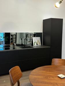 a black kitchen with a sink and a table at Luxury City Apartment Downtown Vienna in Vienna